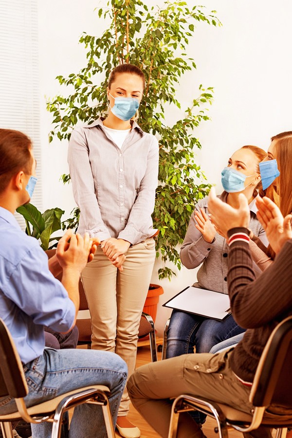 masked woman presents to small business group