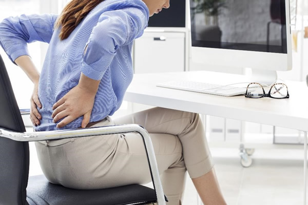 woman with sore back in chair